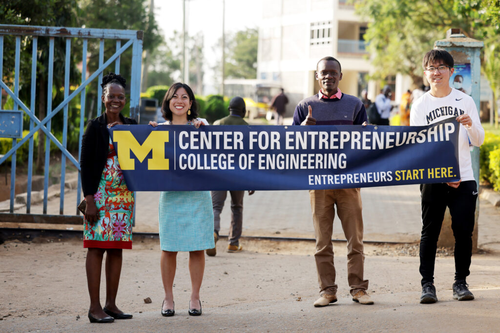 Jooyoung poses with instructor and Warmilu CEO Grace Hsia Halber and others and holds a banner that reads "Center for Entrepreneurship"