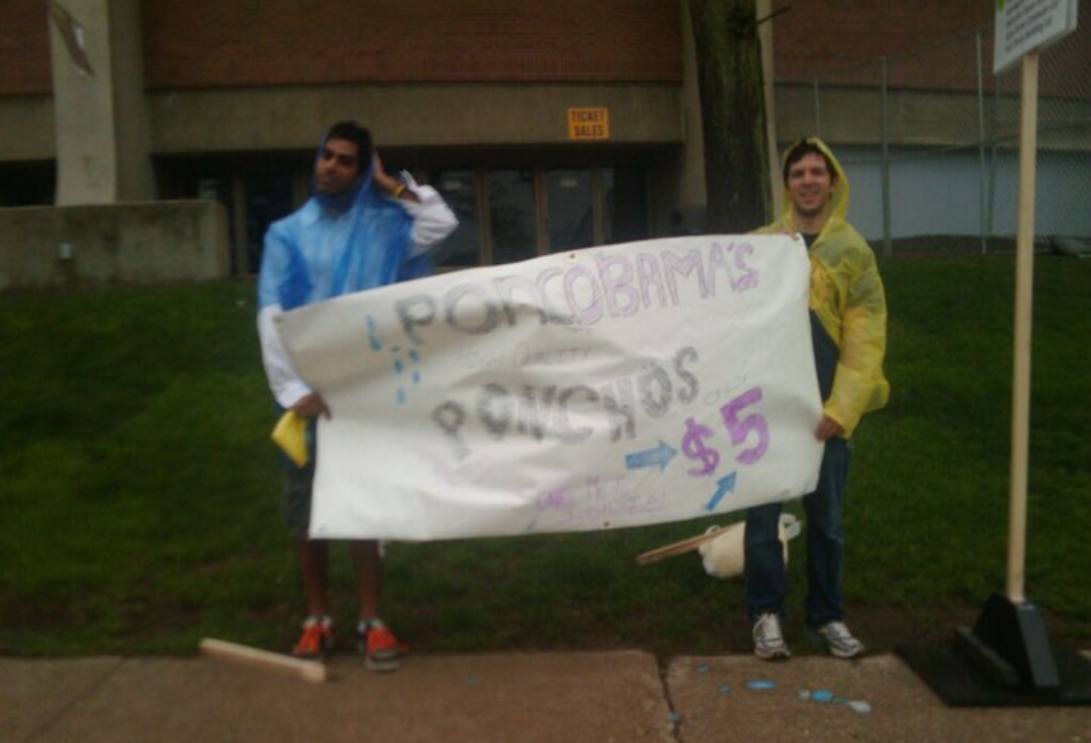 Kumar and a friend with their sign to sell ponchos when President Obama visited campus.