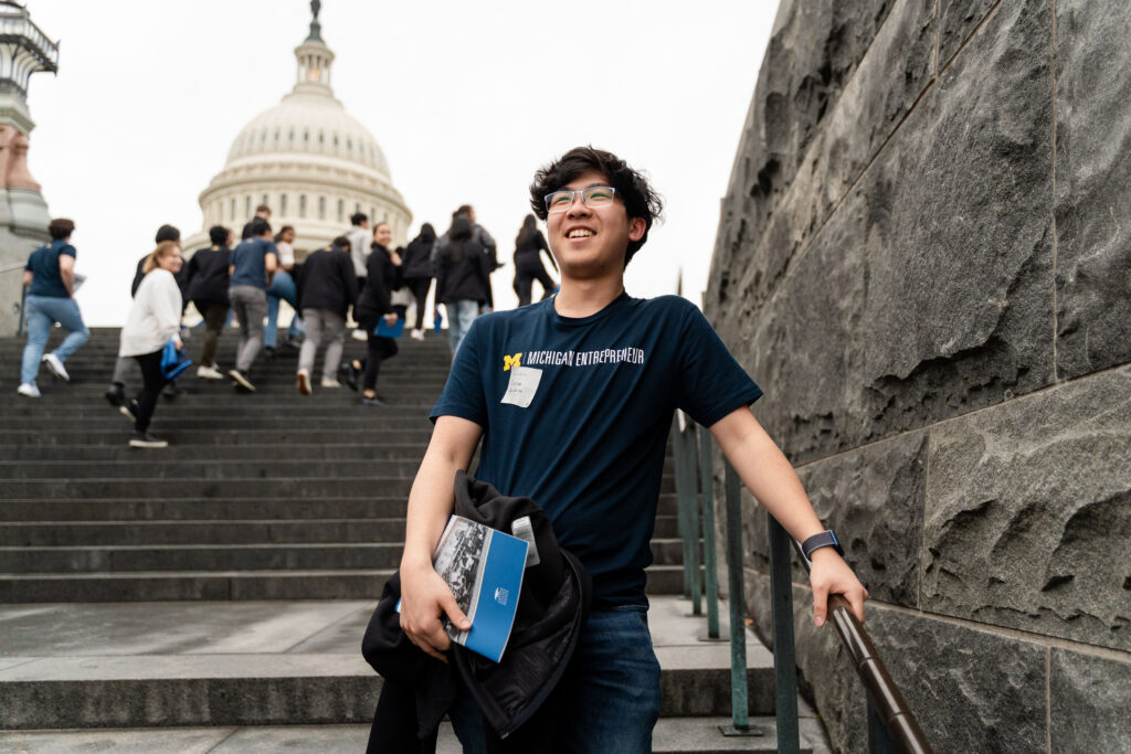 A student smiles in front of the Capitol building