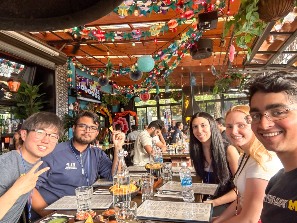 A group of students smile while sitting at a restaurant dinner table in Seattle.