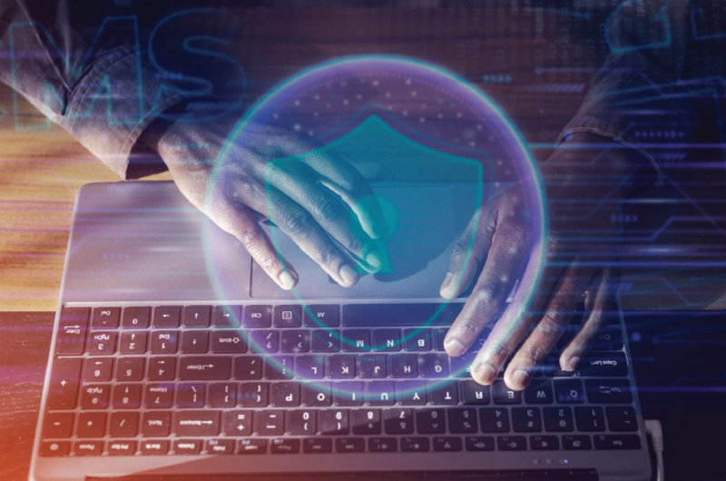 image of hands on a computer creating cybersecurity