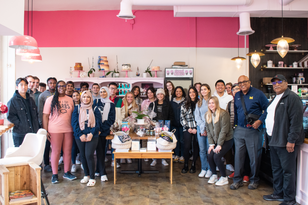Tarver smiles with students at Good Cakes and Bakes in Detroit as part of the Detroit Trek.