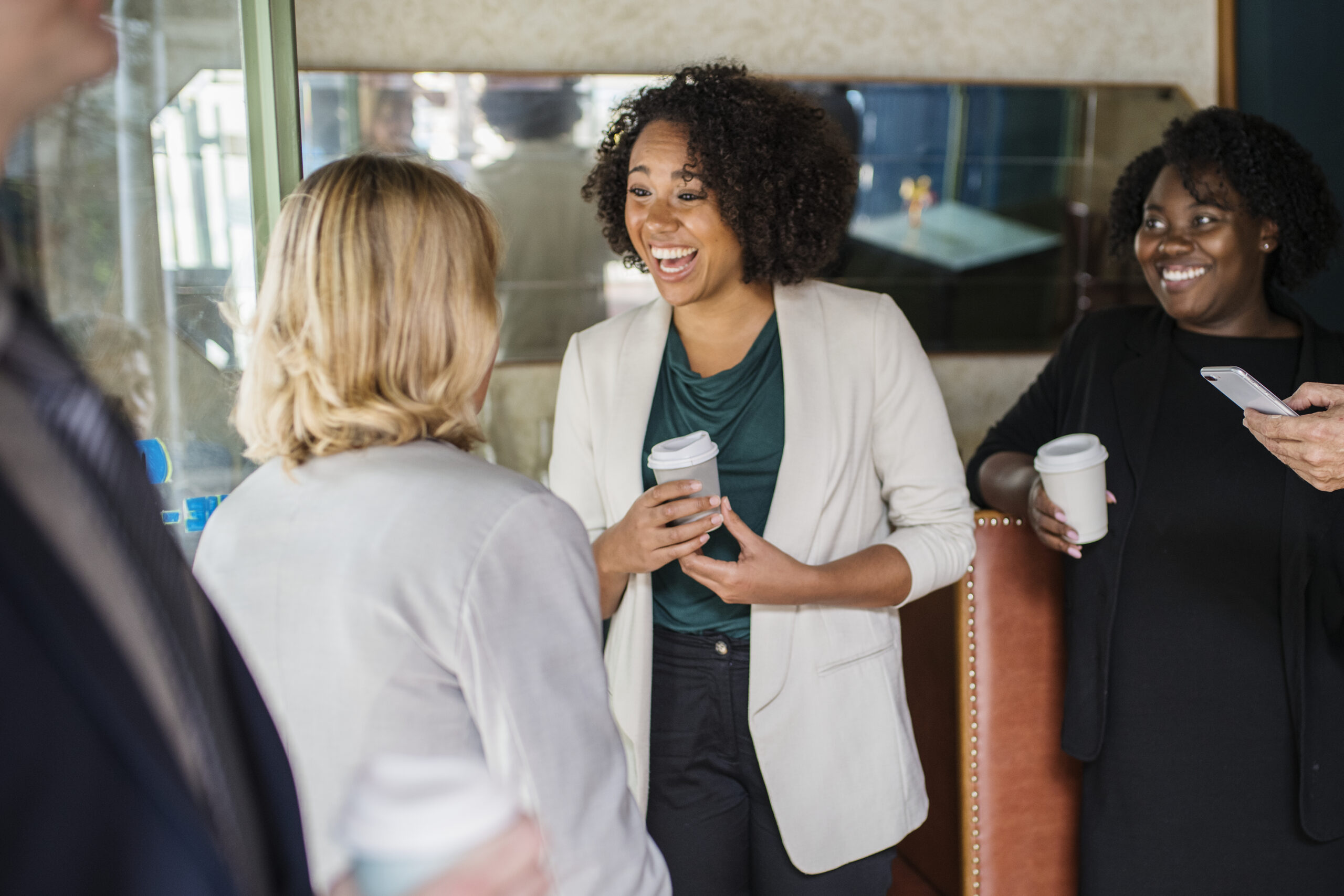 Businesswomen speak with each other at a conference.