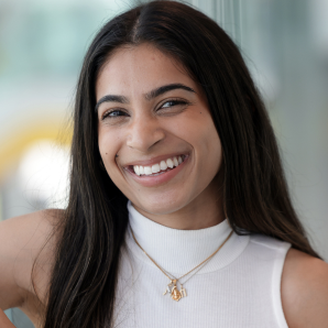 dr nimisha nandankers headshot. A woman with long dark hair wearing a sleeveless white top and gold jewelry