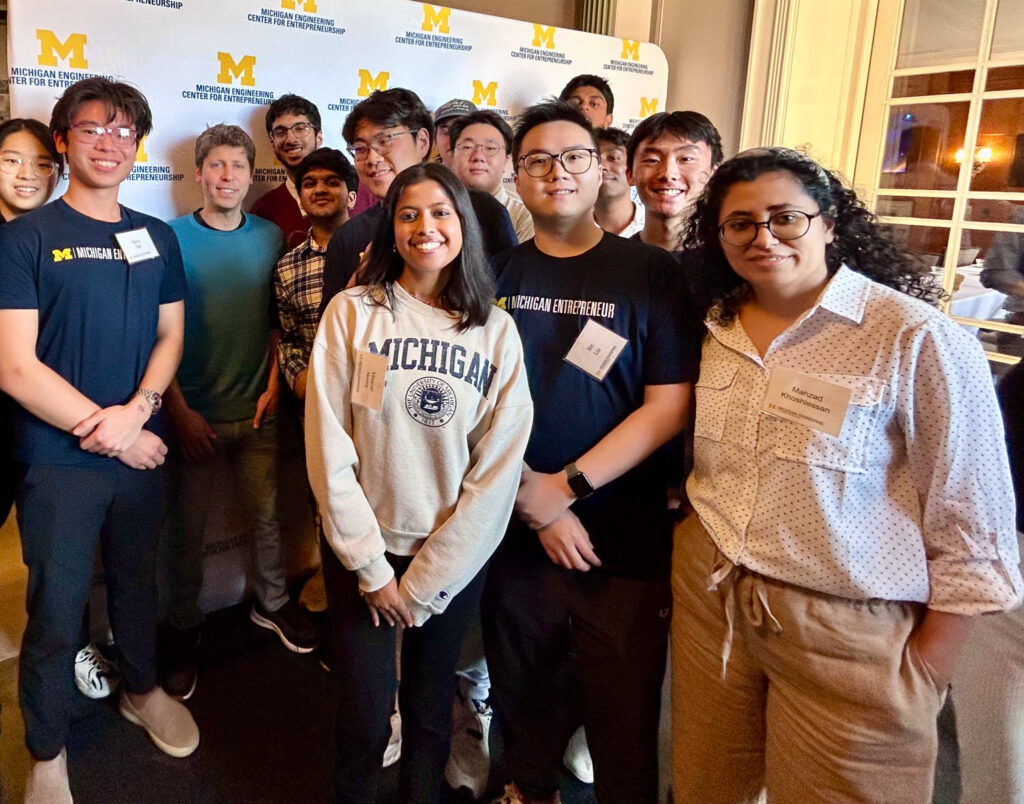 Students smile as they pose with Sam Altman.