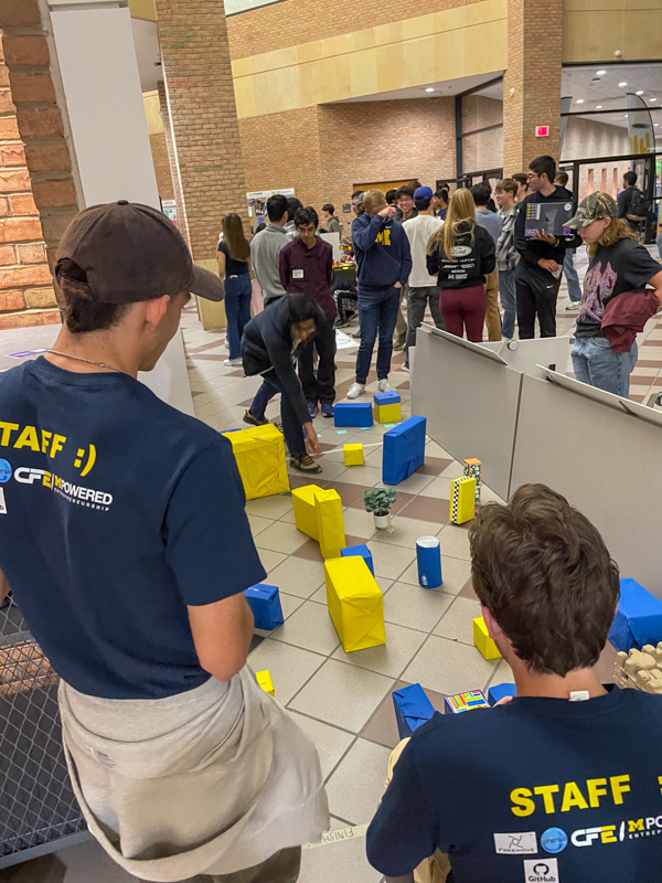 Innovation challenge students working their robot through a blue & yellow block obstacle course