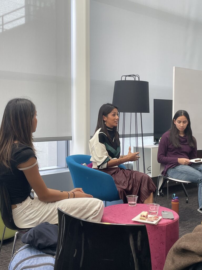 nina reyes sitting with students in a colorful room speaking about women in entrepreneurship