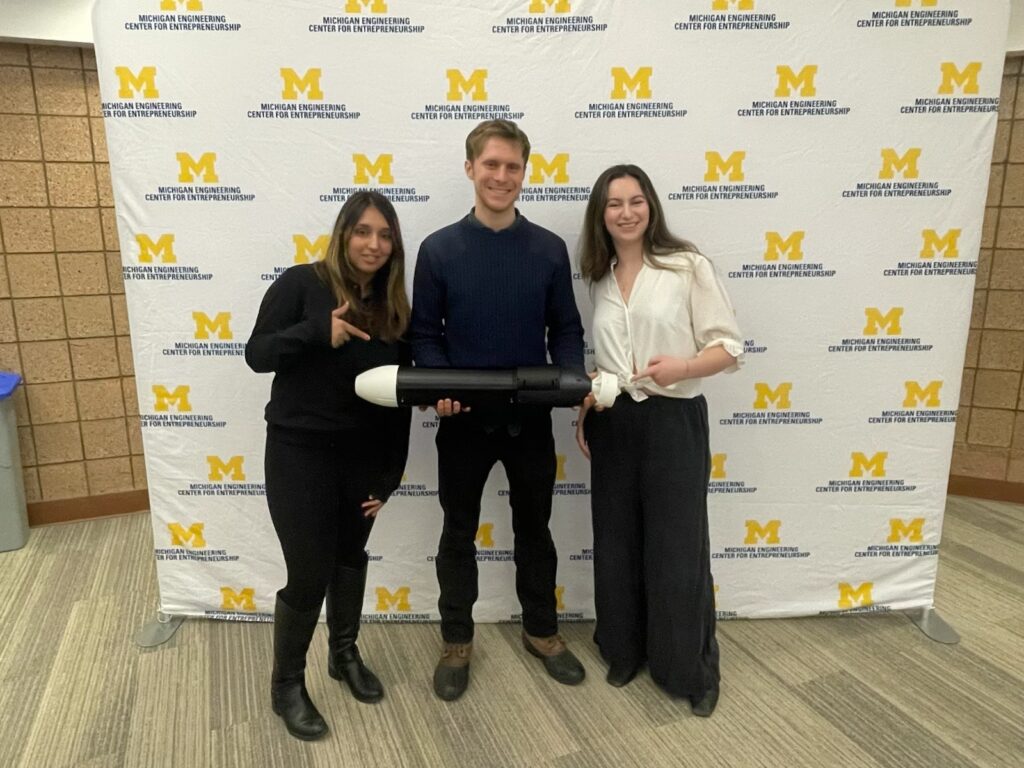 A group of three students pose with a prototype during ELP final presentations.