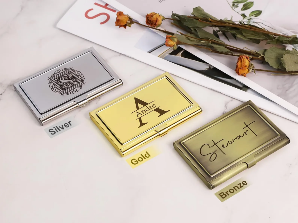 Three business card holders are shown in silver, gold, and bronze.