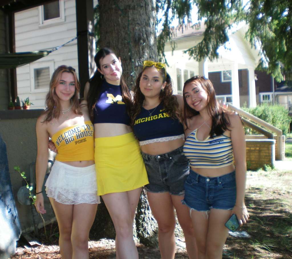 Hannah poses with friends on a football game day.