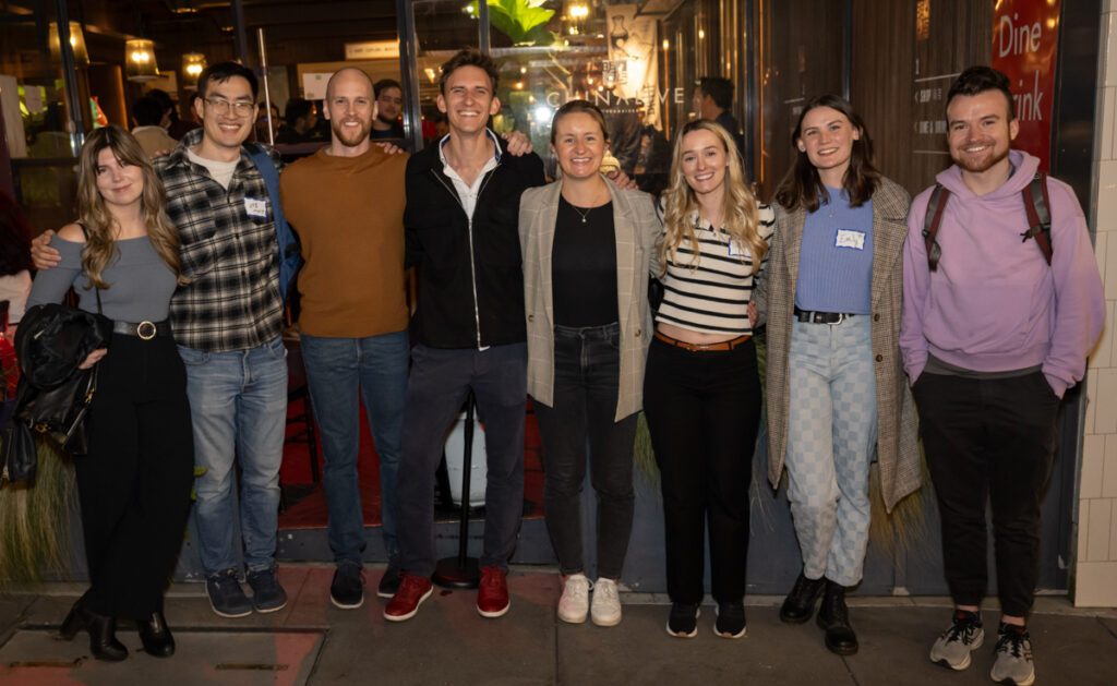 A group of smiling students on a the san francisco trek outside of a restaurant including Arthur Shi