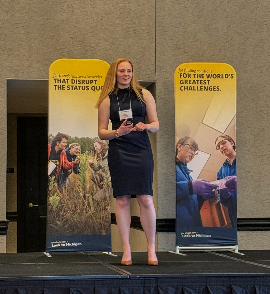 Elyse sorocco on stage in Austin speaking to a group of alumni