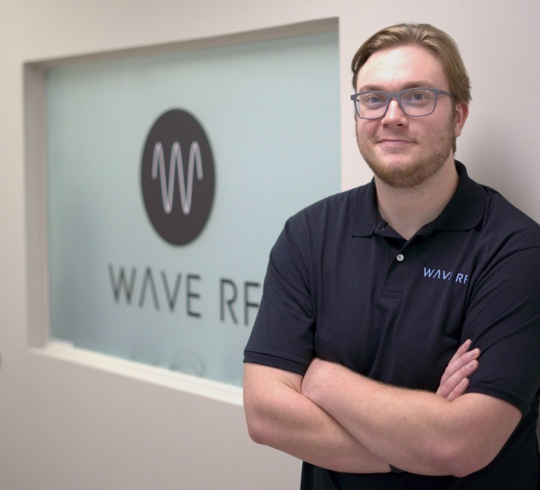 Jack poses in front of a Wave RF logo.