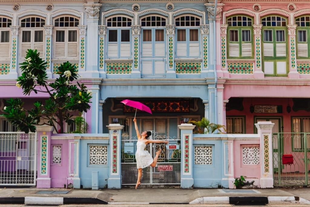 a woman dancing with an umbrella in front of a building