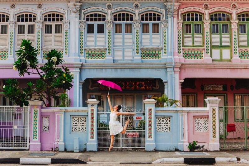 a woman dancing with an umbrella in front of a building