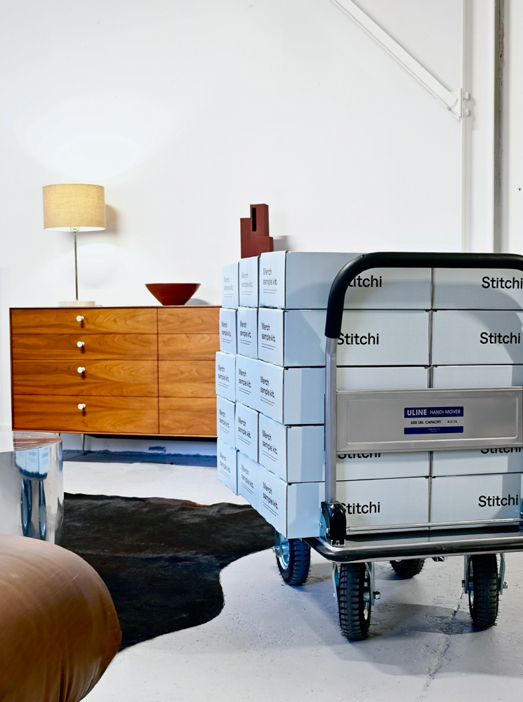 stitchi boxes on a dolly cart with a midcentury modern dresser with a lamp on it in the background