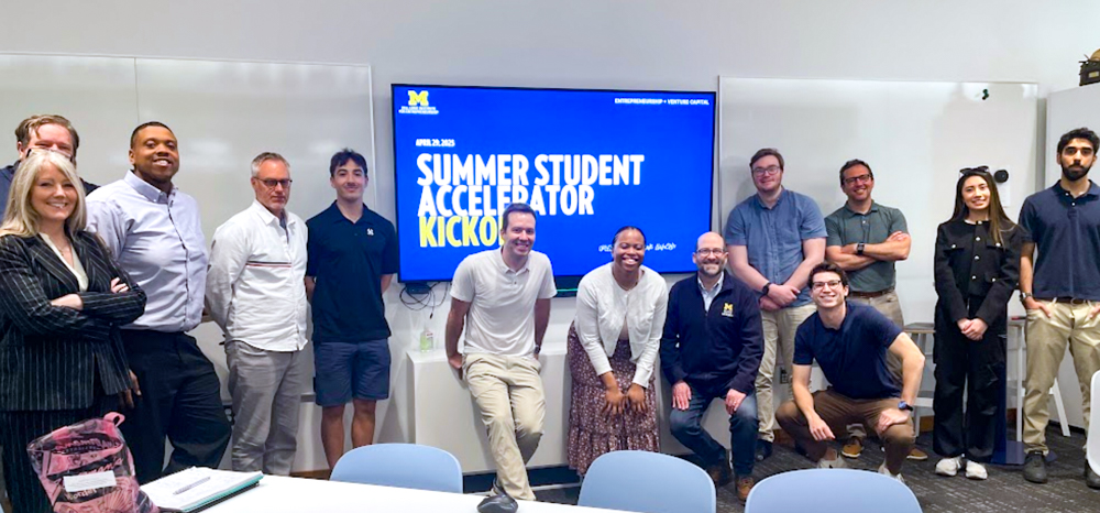 A group of students and staff around a board that says ZLI Summer Student Accelerator Kickoff.