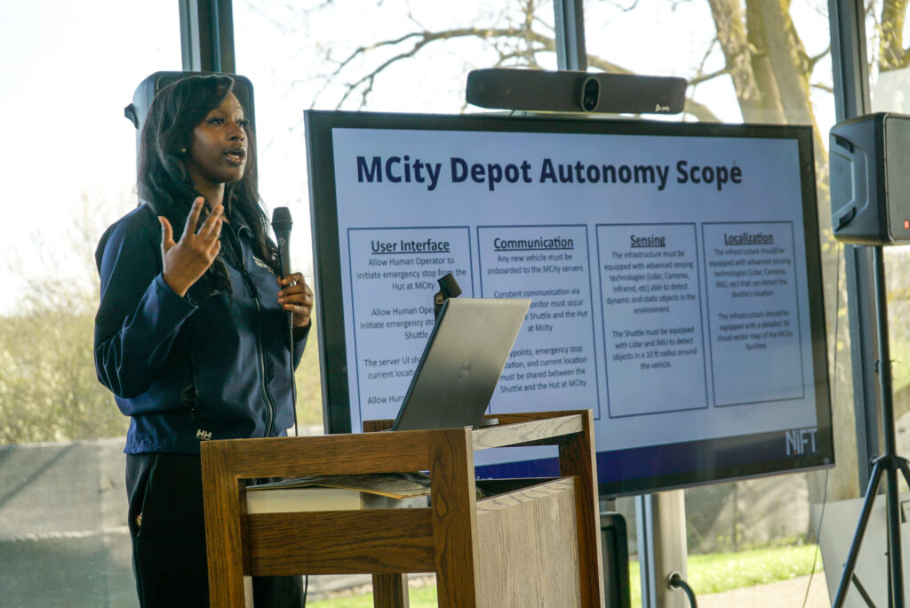 A student during their presentation at a podium talking about Mcity depot autonomy scope