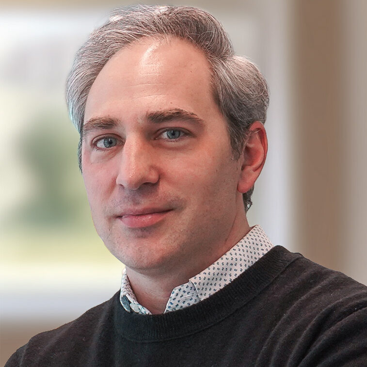Nick moroz headshot wearing a navy sweater with a white shirt underneath
