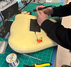 a pair of hands with a welding gun assembling a motion sync pillow cover