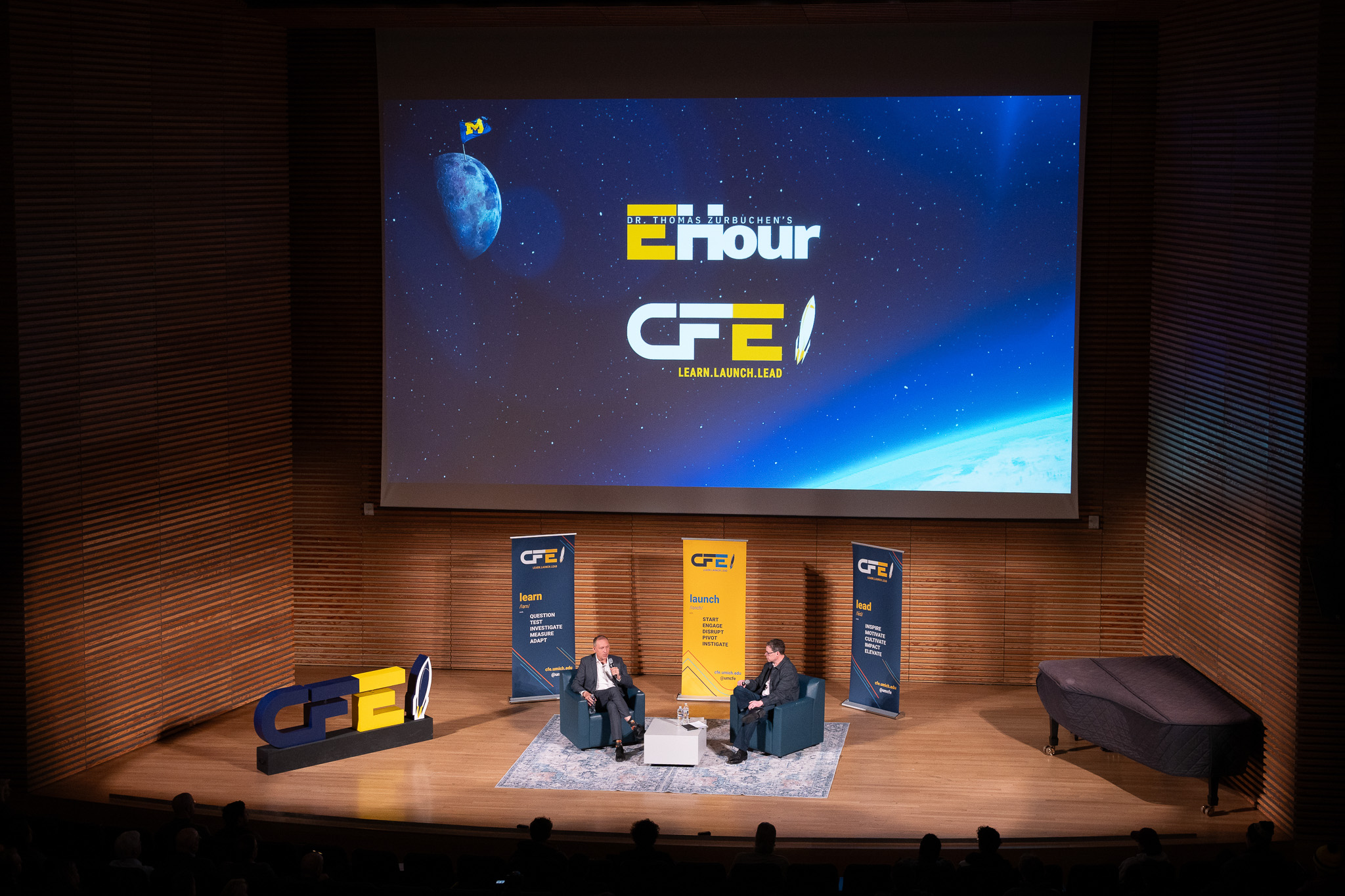 Eric sits with Dr. Thomas Zurbuchen, founder of the CFE, on stage at EHour.