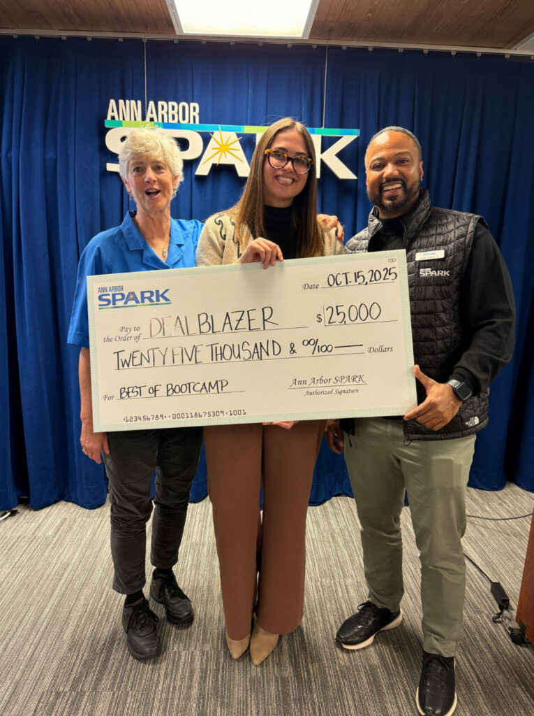 Kaylin eighmey holding a big check with a man and a woman on each side