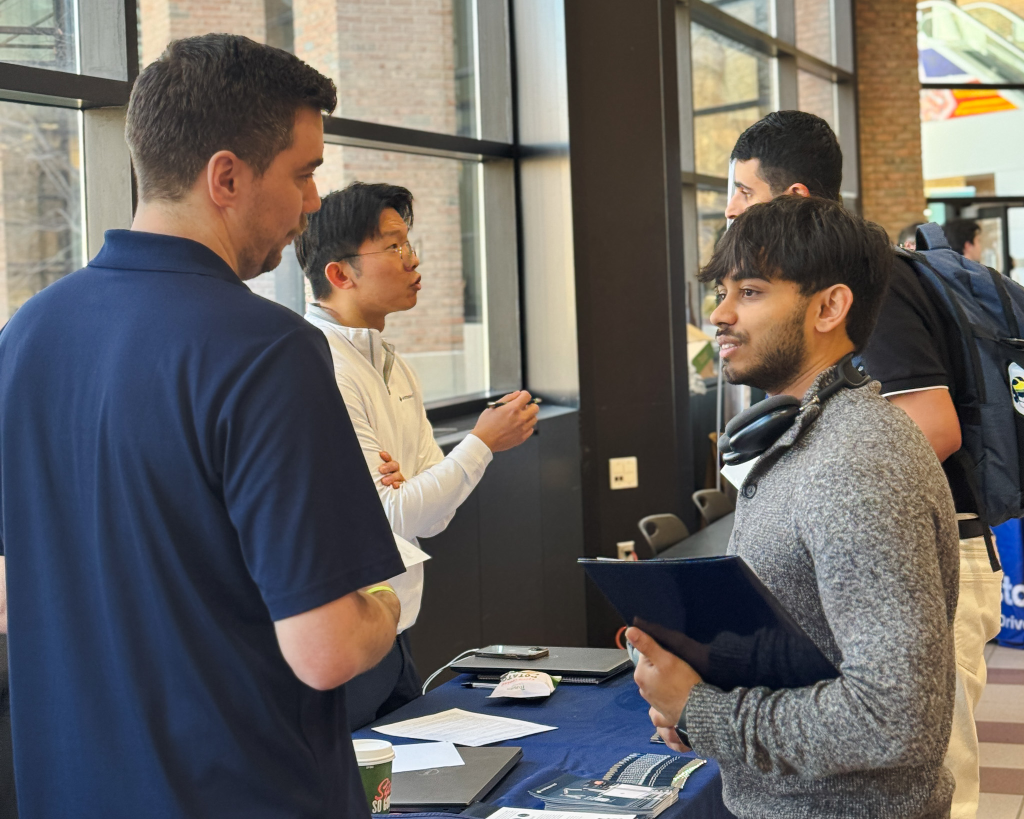 Two students are shown interacting with startup representatives at the Startup Career Fair.