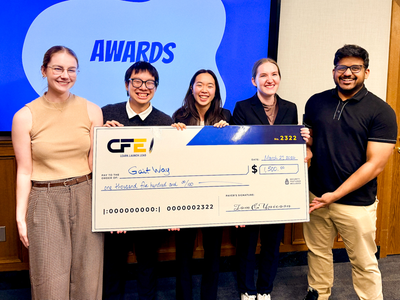 winners of mtank holding a big check. A group of five students