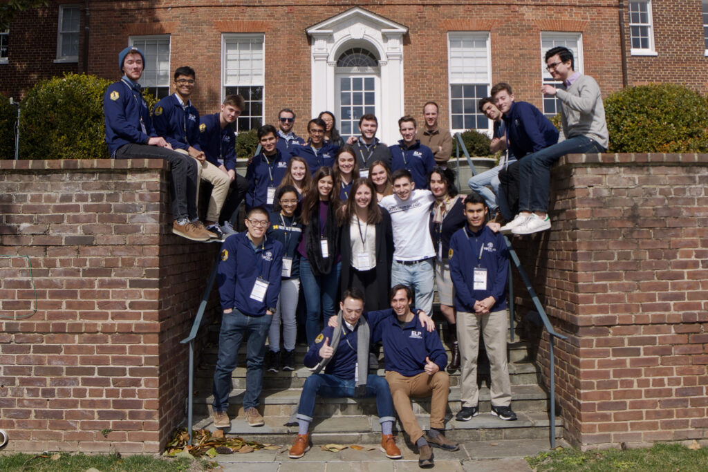 Mira poses with fellow students on an ELP trek. The large group sports Michigan gear. They stand on a stairway surrounded by brick.