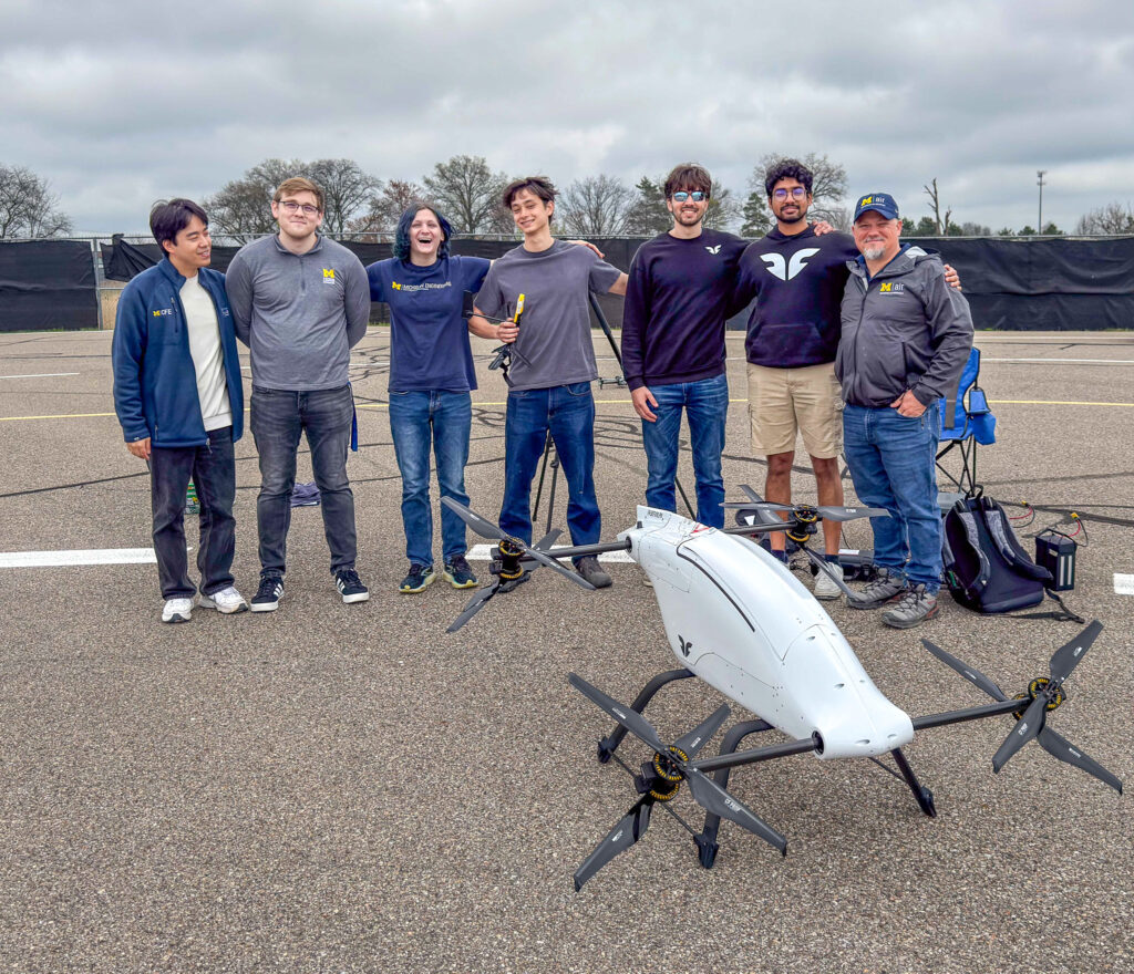 a group of students outside with a drone