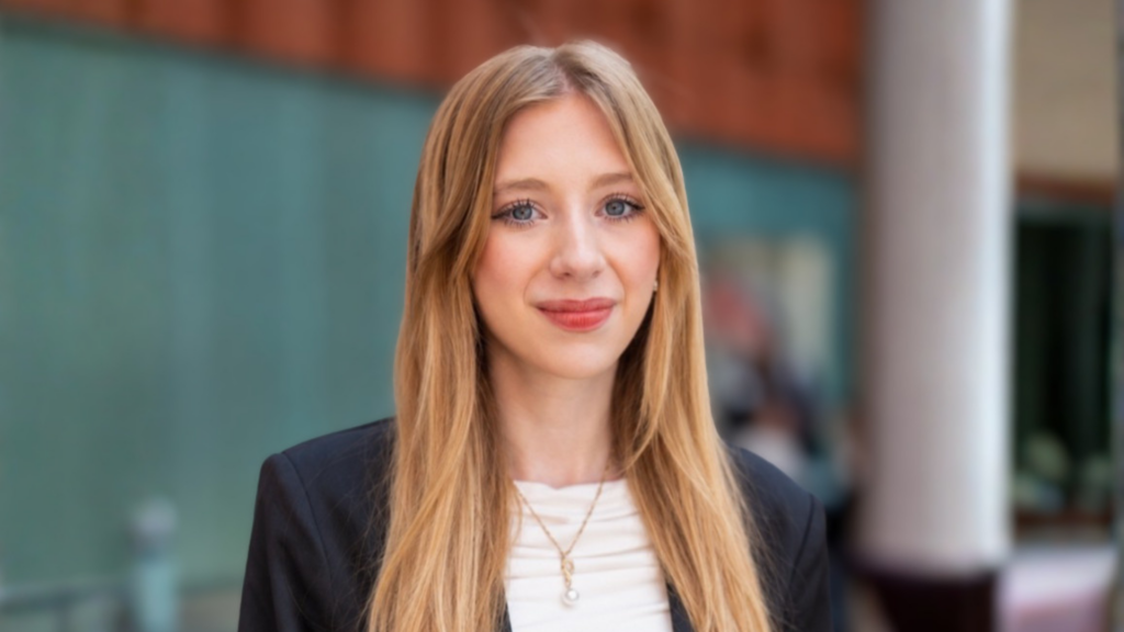 Delaney Ross poses for a headshot at the Ross School of Business. She wears a white shirt and black blazer.