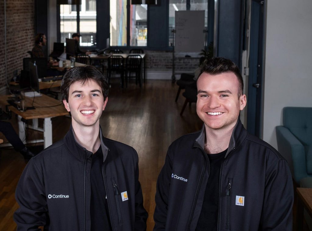 Ty Dunn poses with co-founder wearing a jacket that displays the Continue logo