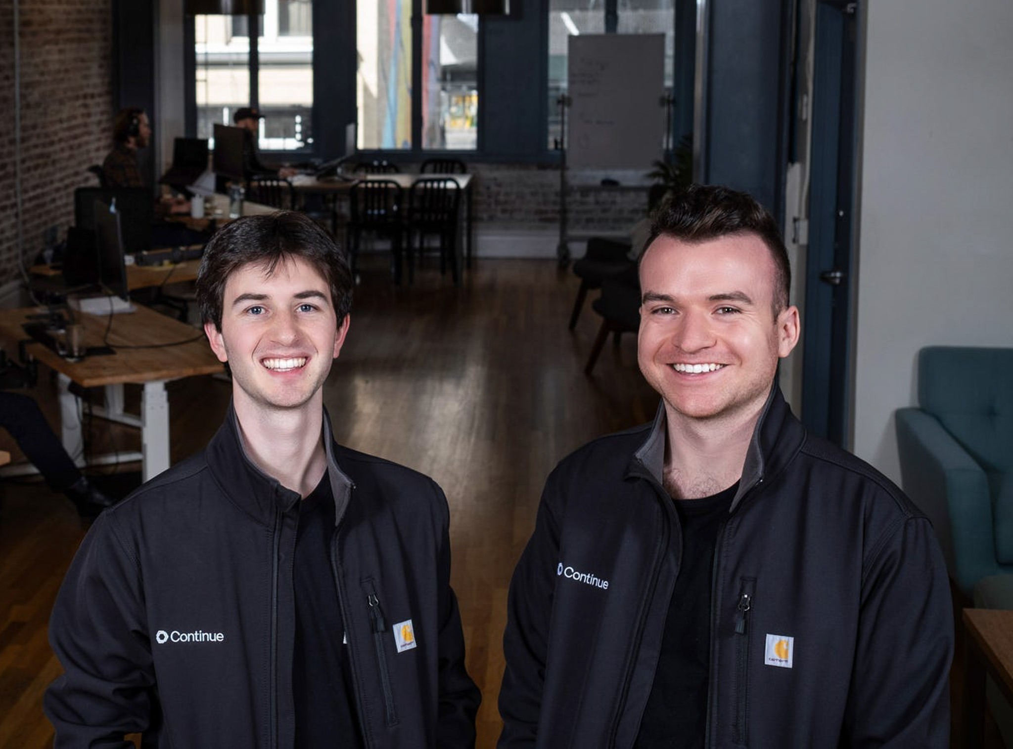 Ty Dunn poses with co-founder wearing a jacket that displays the Continue logo