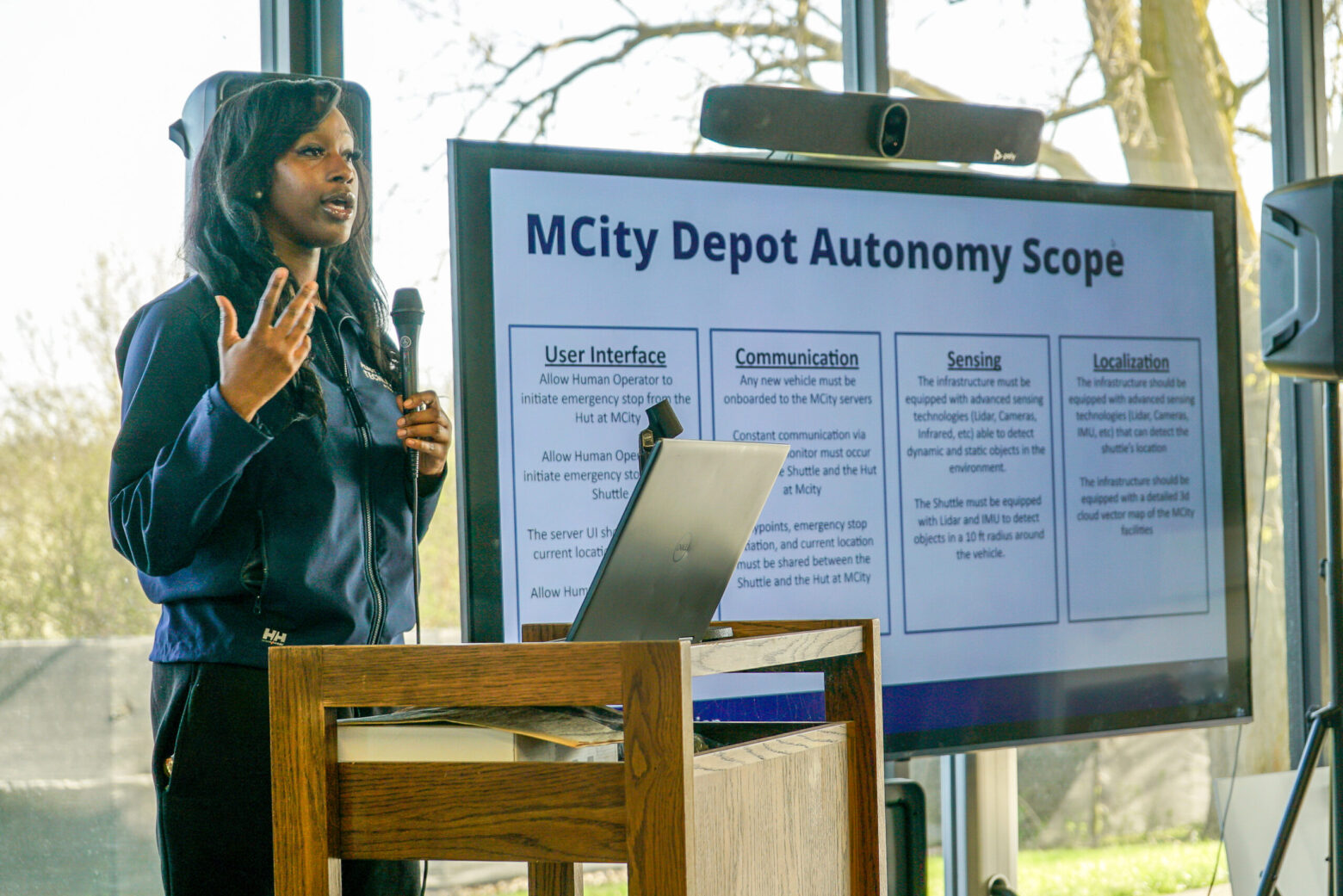 a woman giving a presentation in front of a group of students and mentors