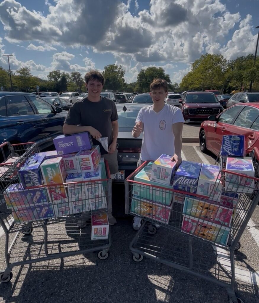 Isaac and co-founder Zach pose with carts full of Alani energy drinks, which they handed out to promote Ticko.