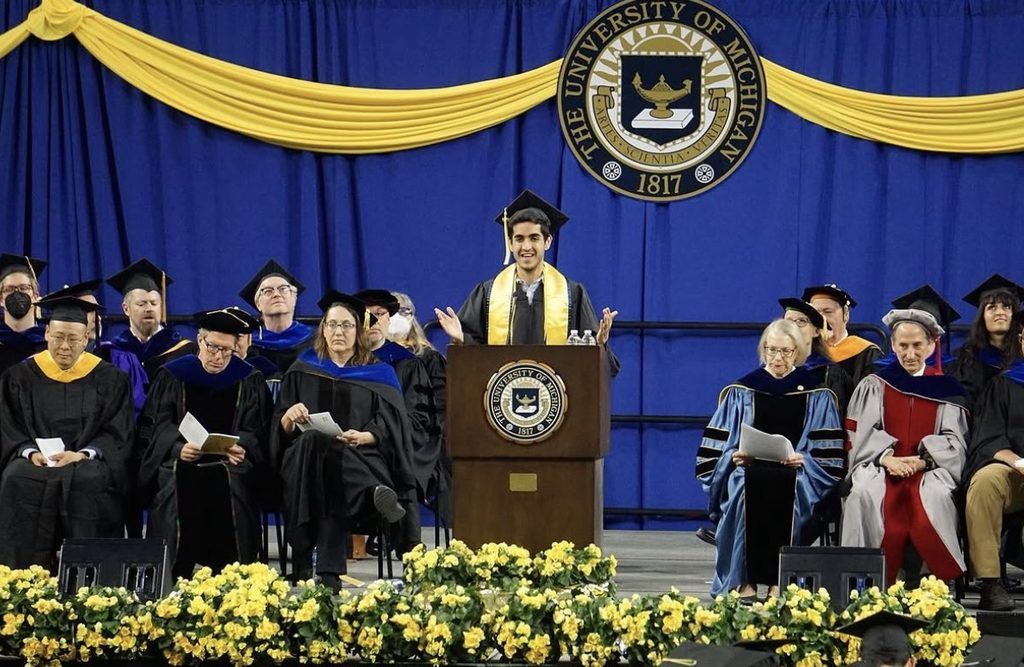 Arjan speaks on stage at a University of Michigan graduation ceremony