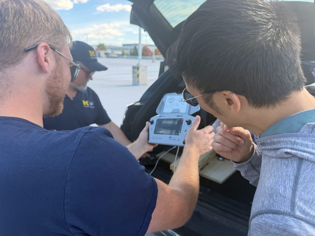 two men looking at a drone controller